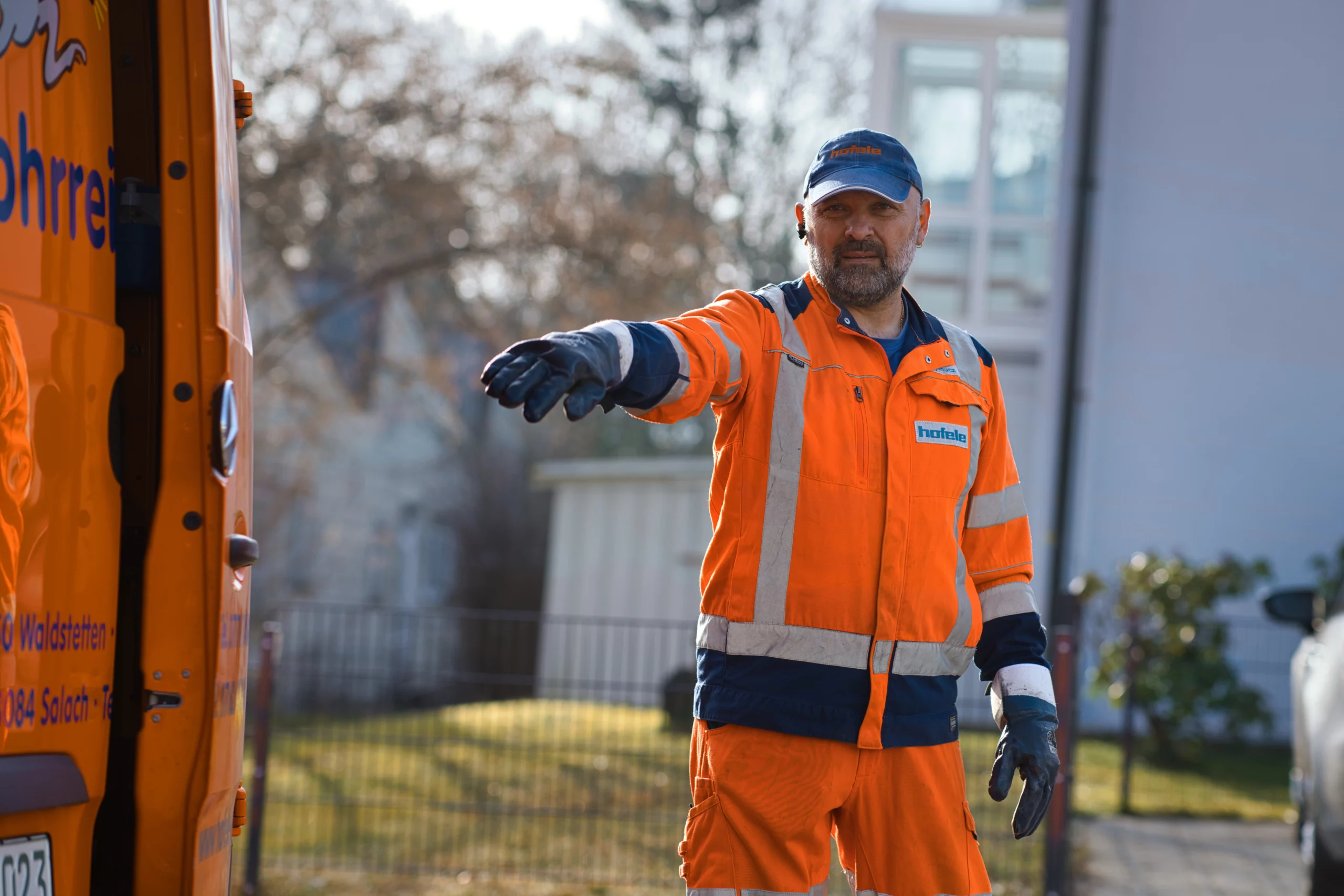 Dichtheitsprüfung direkt vor Ort Mitarbeiter in orangefarbener Arbeitskleidung im Außeneinsatz