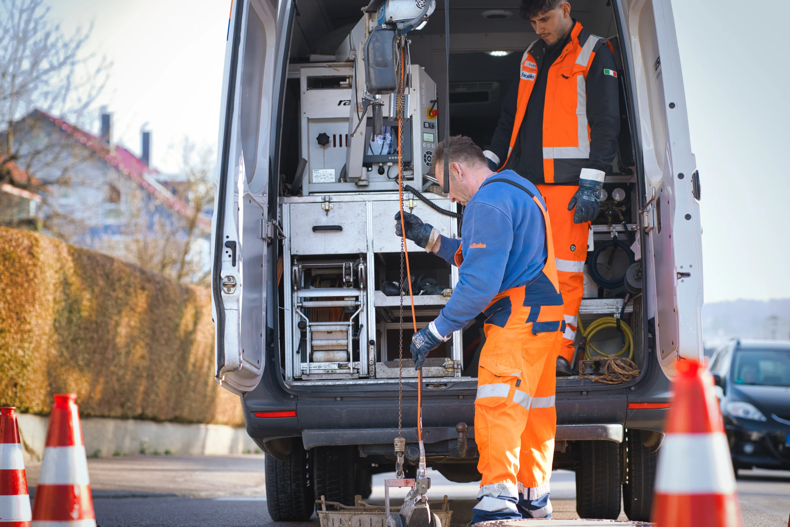 Mitarbeiter bedient Saugtechnik am geöffneten Einsatzfahrzeug