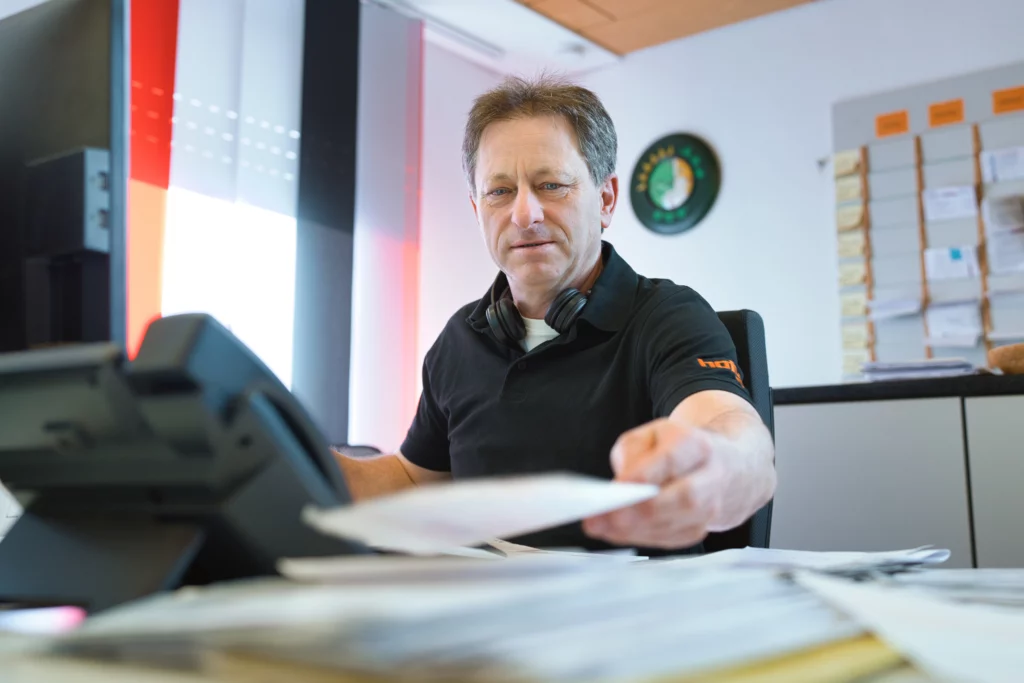 Mann prüft eine überhöhte Rechnung für einen Rohrreinigungsnotdienst am Schreibtisch