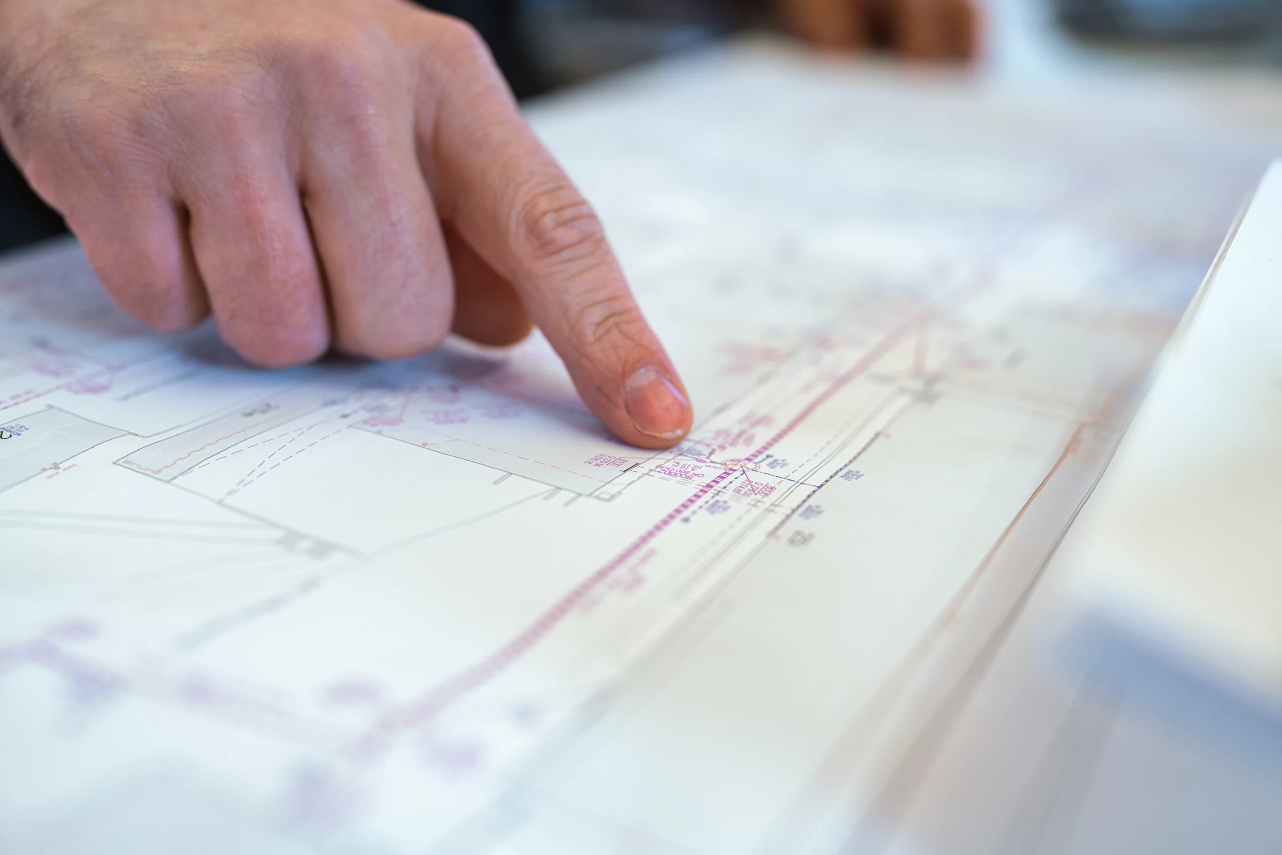 Planung und Auswertung einer Schachtinspektion Hand zeigt auf einen technischen Plan zur Schachtinspektion